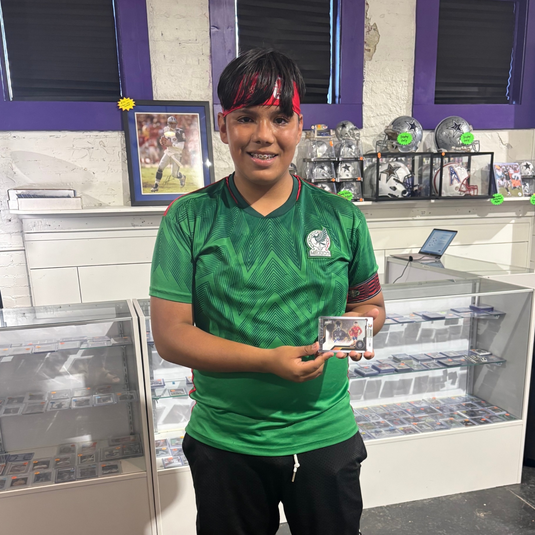 Collector holding a soccer card in front of the display cases