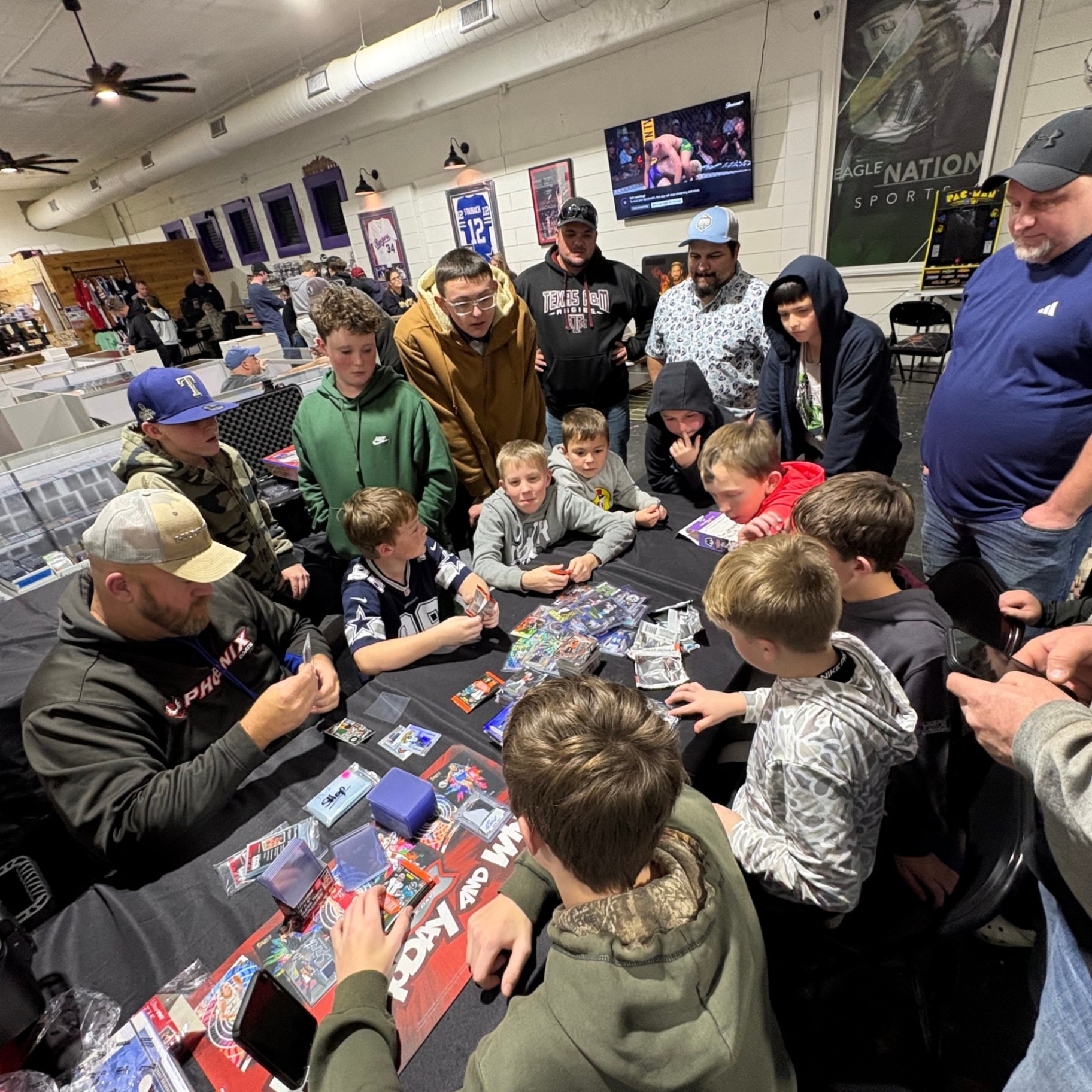 Kids and parents gathered around a pack opening table